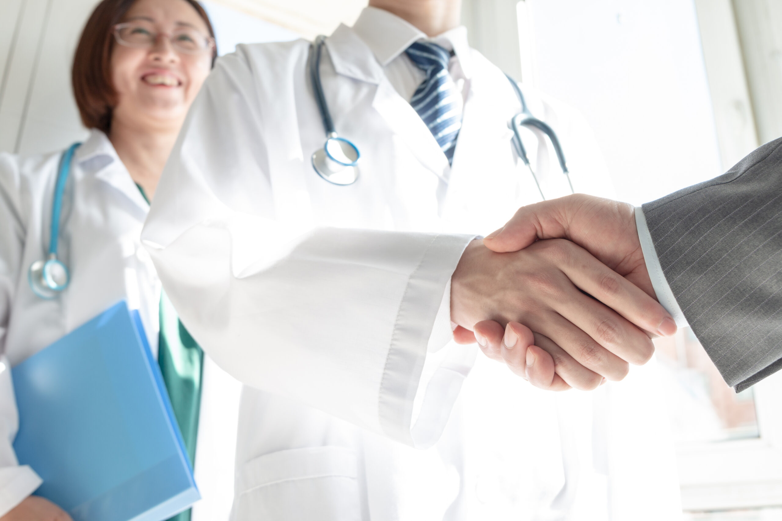 Doctor and business people shaking hands